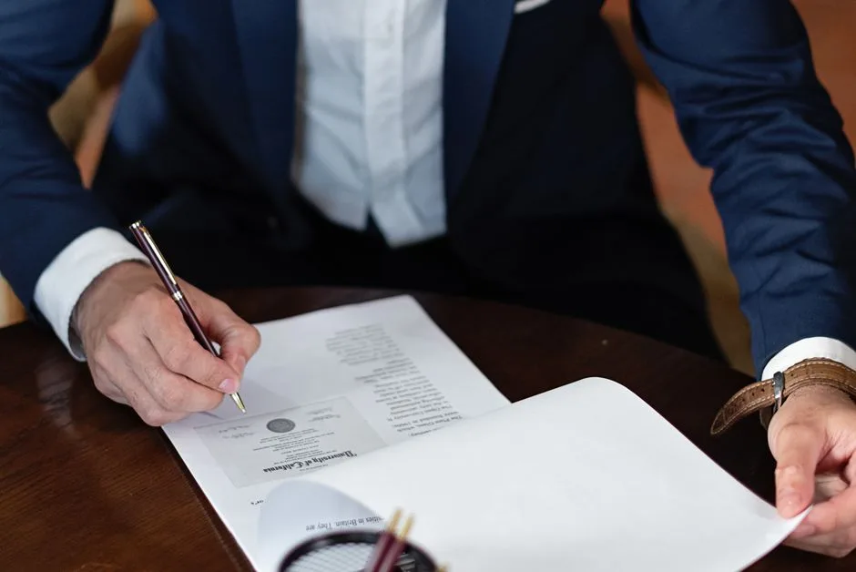 Mesa de mármore preto com documentos jurídicos e caneta sobre contrato